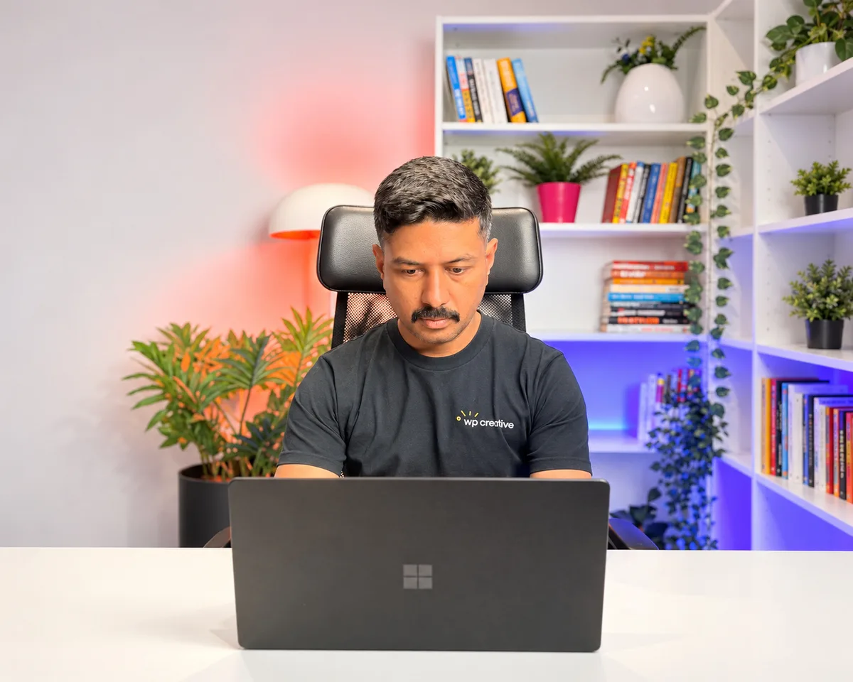 Nirmal Gyanwali working on a laptop in a WP Creative T-shirt